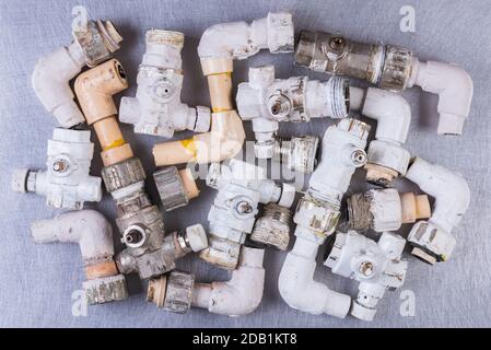 Old plumbing water fittings on grey metal surface, directly above view Stock Photo