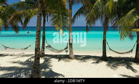 Beautiful tropical island with sand beach and hammock. Panglao, Philippines. Seascape with beautiful beach and palm trees. Stock Photo