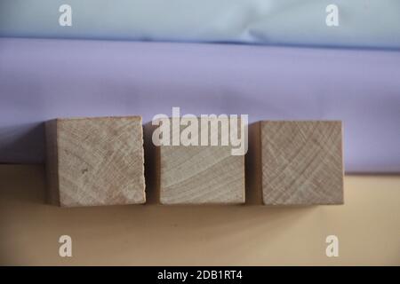 Three wooden cubes on table over blur abstract light background. Building business idea concept Stock Photo
