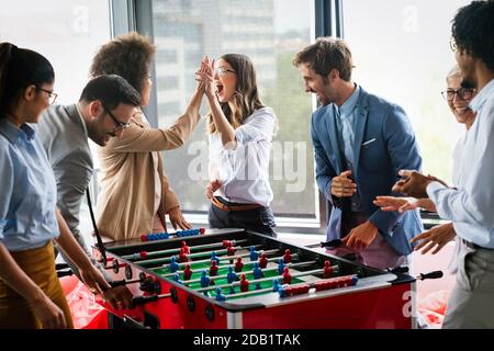 Excited diverse employees enjoying funny activity at work break, creative friendly workers play game Stock Photo