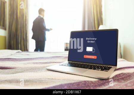 Delivery order tracking. Focus on laptop with application and image of truck on screen on bed in home Stock Photo