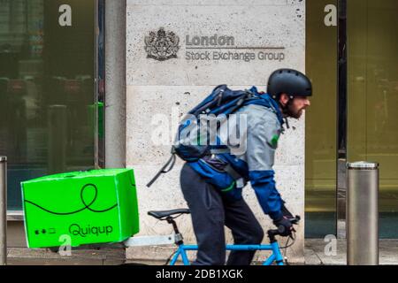 London Stock Exchange - a Quiqup Bike Courier passes the London Stock Exchange building at 10 Paternoster Row in the City of London Financial District Stock Photo