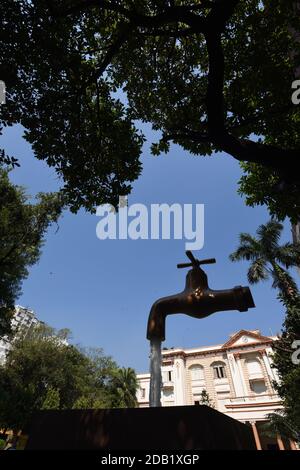 Giant Magic Tap, an outdoor floating tap fountain hovering above a pool, with endless supply of water gushing out of it, seemingly from nowhere, this Stock Photo