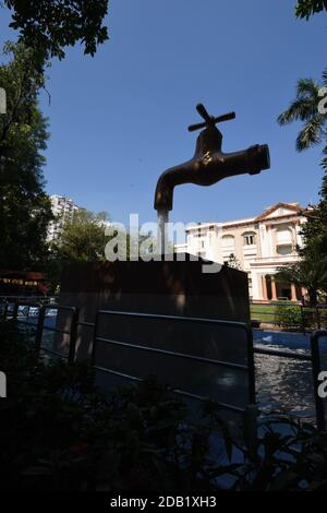 Giant Magic Tap, an outdoor floating tap fountain hovering above a pool, with endless supply of water gushing out of it, seemingly from nowhere, this Stock Photo