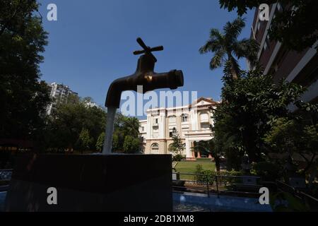 Giant Magic Tap, an outdoor floating tap fountain hovering above a pool, with endless supply of water gushing out of it, seemingly from nowhere, this Stock Photo