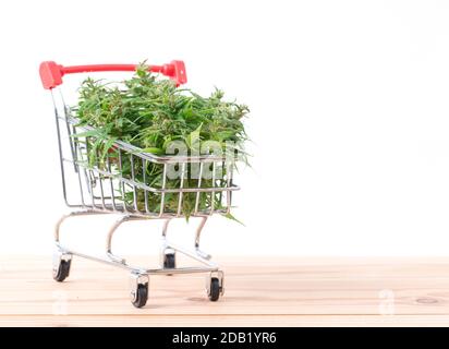 fresh marijuana flower in shopping cart on table Stock Photo