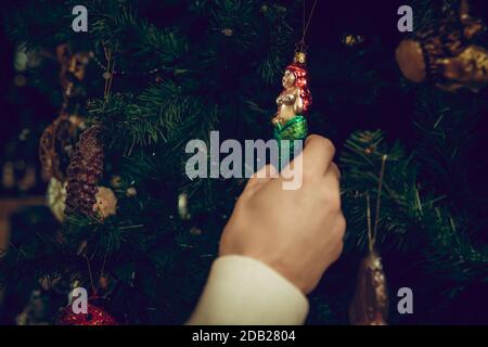 Christmas tree. Close up female hands looking for home decoration and holiday's gifts in household store. Stylish and retro things for greetings or design. Interior renovation, celebrating time. Stock Photo