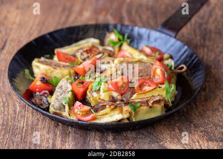 swabian maultasche with onions in an iron pan Stock Photo