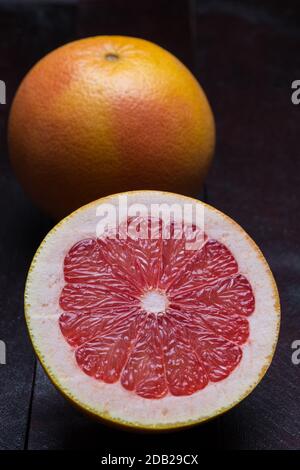 Grapefruit sliced on mahogany wood background. Stock Photo