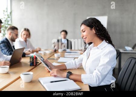 Mexican Businesswoman Using Digital Tablet On Corporate Meeting In Office Stock Photo