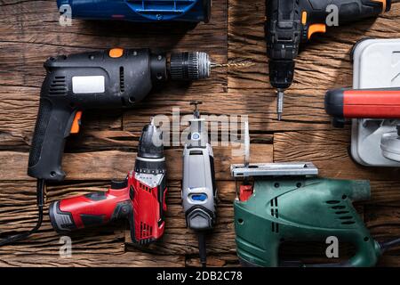 Various Power Tools Laying On Wooden Desk Stock Photo