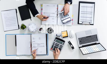 High Angle View Of Two Businesspeople Calculating Bills In Office Stock Photo