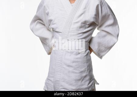 Stages of correct tying of the belt by a teenager on a sports kimono, step three Stock Photo