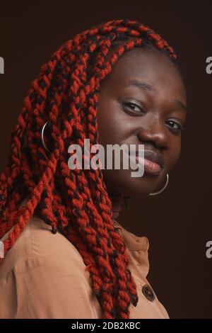 Vertical close up portrait of stylish young African-American woman with braided hair looking at camera while posing confidently in studio Stock Photo