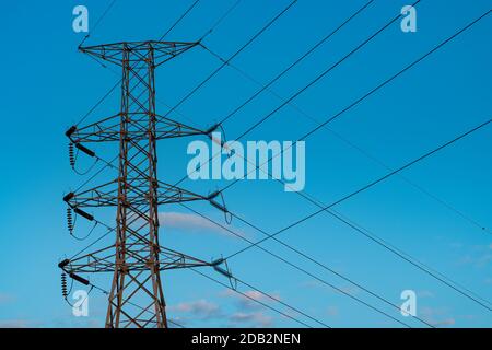 Electric power line tower isolated on blue sky background Stock Photo