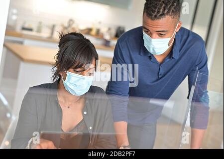 Start-up people working in co-working space office, wearing face mask during 19-ncov pandemic Stock Photo