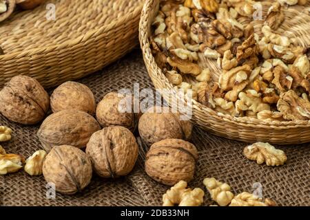 Walnuts on rustic natural burlap, Walnut kernels in wicker basket, Walnut background Stock Photo