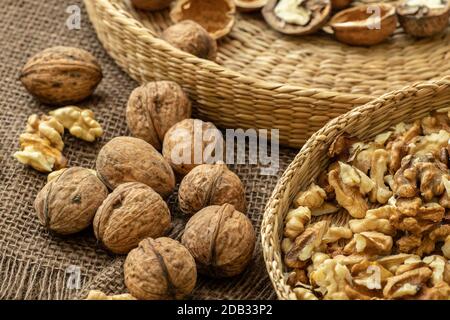 Walnuts on rustic natural burlap, Walnut kernels in wicker basket, Walnut background Stock Photo