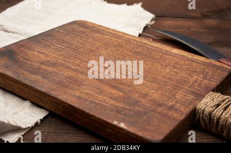 very old empty wooden rectangular cutting board and knife, close up Stock Photo