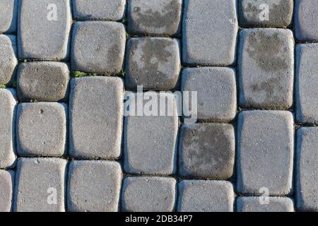 Granite cobblestoned pavement background. Full frame of regular square cobbles in rows. Natural stone textured background Stock Photo