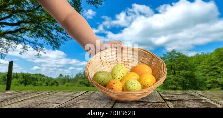 a hand holds an easter basket with easter eggs Stock Photo