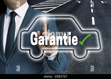 Garantie (in german Warranty) with car touchscreen is operated by man. Stock Photo