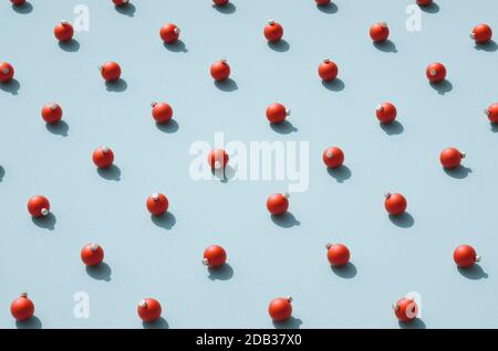 High angle view of red matt round Christmas balls against retro cyan / blue surface. Various orientation of Christmas ornaments standing in rows on te Stock Photo