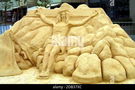 SAND ART - SEVILLE, SPAIN, in 2007. A sand sculpture depicting Jesus on the cross with Mary kneeling beside him. Stock Photo