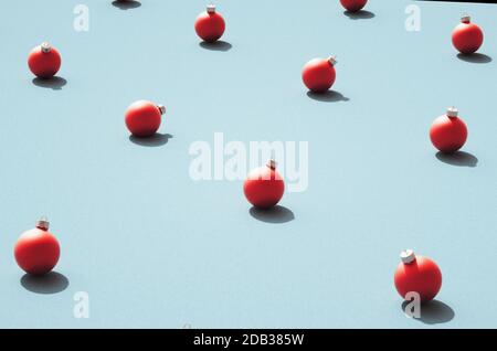 High angle view of red matt round Christmas balls against retro cyan / blue surface. Various orientation of Christmas ornaments standing in rows on te Stock Photo