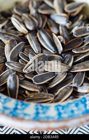 Close-up of Sunflower Seeds in their Shell in a Patterned Earthenware Bowl of Blue and Orange - FOODPIX Stock Photo