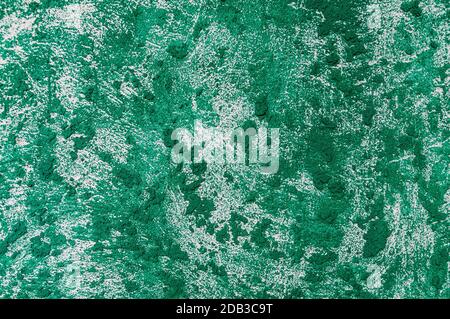 texture of the wall covered with relief plaster and painted green Stock Photo