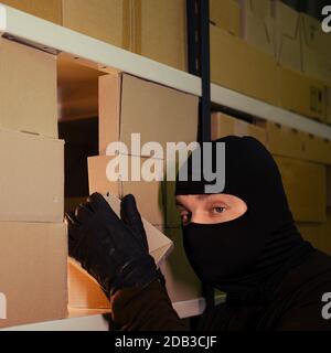 A man in black mask steals kidnapping child, close-up, black and white ...