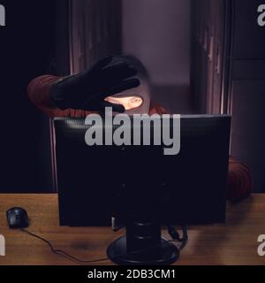 Hacker near server equipment in hand with black glove. Concept of data security problems and network hacking Stock Photo