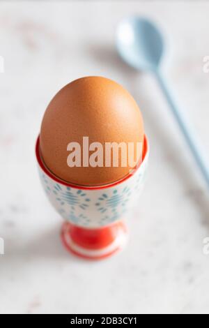Boiled Egg in Colourful Blue and Red Egg Cup with Spoon on a White Marble Background – FOODPIX Stock Photo