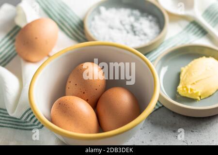 Bowl of Fresh Eggs with Butter and Salt on a White and Green Striped Linen Napkin – FOODPIX Stock Photo