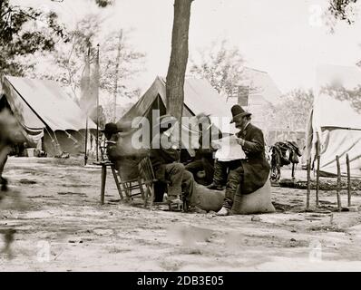 Gen. Ambrose E. Burnside (reading newspaper) with Mathew B. Brady (nearest tree) at Army of the Potomac headquarters. Stock Photo