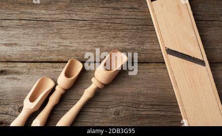 empty wooden spoon and vintage grater for vegetables on a gray wooden background, top view Stock Photo