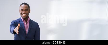 Happy Young Businessman Extending Hand To Shake Stock Photo