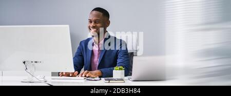 African Businessman Banner Using Computer In Office Stock Photo