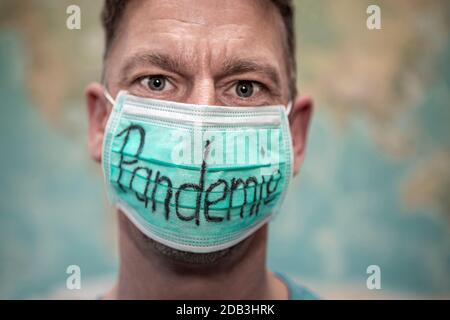 Caucasian man with mouth guard in front of whole world map, pandemic Stock Photo