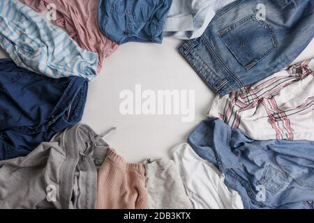 Many colorful clothes are lying on the floor. The view from the top Stock Photo