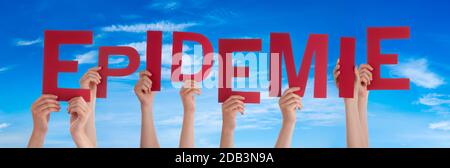 People Hands Holding Red German Word Epidemie Means Epidemic. Blue Sky As Background Stock Photo