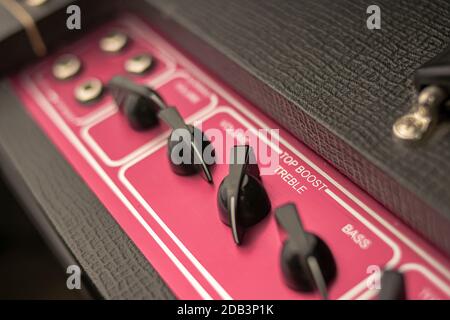 Close-up of the knobs of a classic rock and roll music amplifier, with regulators for volume, bass and treble, of the top boost system. Stock Photo