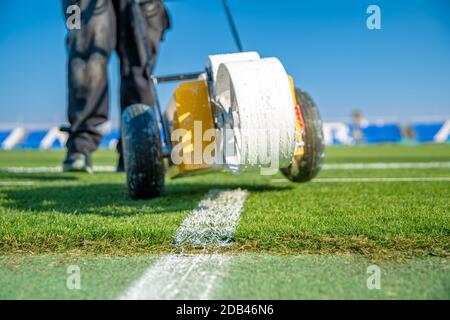 Lining a football pitch using white paint on grass. Stock Photo