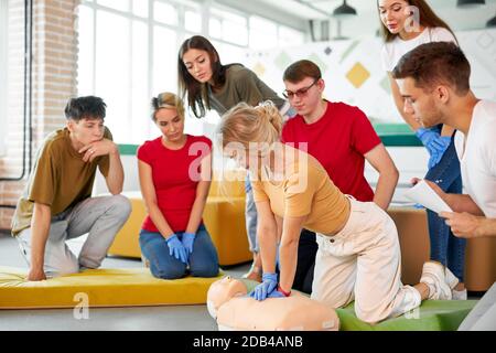 woman in first aid class exercising reanimation on dummy, indoors Stock Photo