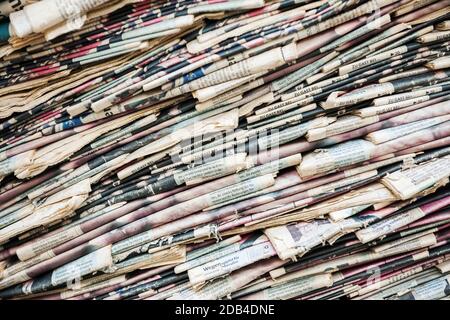 Full-page view of old and yellowed diagonally stacked daily newspaper Stock Photo