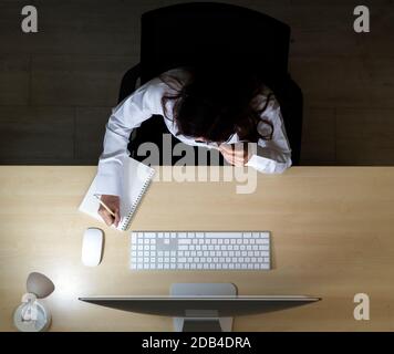 Late Night Environment. Top view of young adult friendly operator call center with headsets working hard at night. Using for 24 Hr. 7 days Call centre Stock Photo