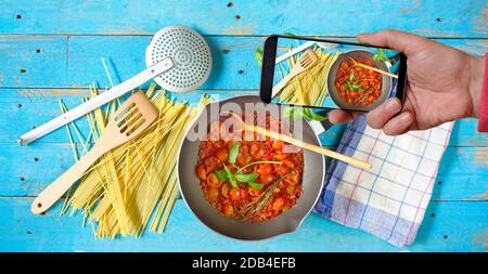 shooting with smartphone the preparation of oganic italian spaghetti dish,spaghetti, kitchen utensils, healthy food,cooking,restaurant,concept Stock Photo