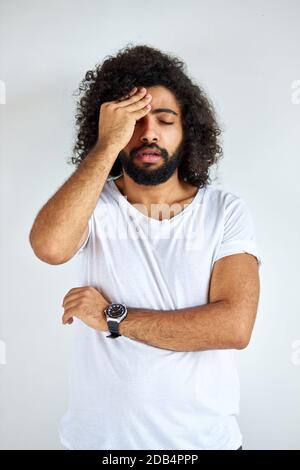 portrait of thoughtful young arabic arabian male isolated in studio, curly dark haired male is thinking about question, pensive expression. doubt concept. Stock Photo