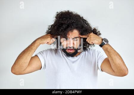 portrait of thoughtful young arabic arabian male isolated in studio, curly dark haired male is thinking about question, pensive expression. doubt concept. Stock Photo